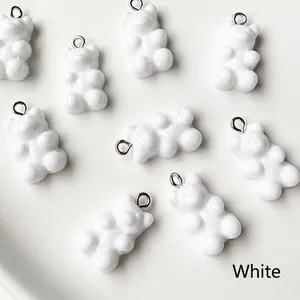 Macro view of glossy white resin bear charms with metal loops for DIY jewelry making