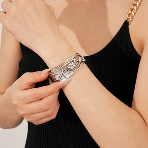 Detail of silver vintage open bangle featuring butterfly and flower hollow engravings