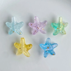 Macro view of colorful gradient starfish beads with gold glitter for DIY jewelry making