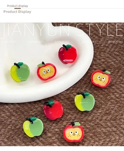 Detailed view of DIY resin apple charms in various colors on a white ceramic heart dish