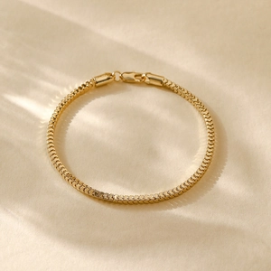 Close-up of a polished 14K gold plated box chain bracelet with elegant metallic texture