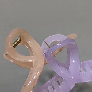 Detailed macro view of apricot and lavender jelly hair claws with metal spring mechanism