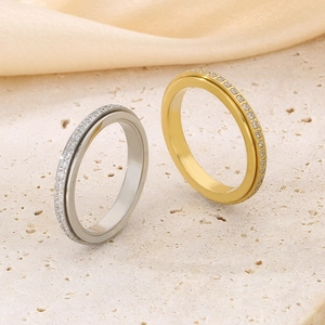 Close-up of two rotatable titanium steel rings in gold and silver with row of zircon