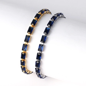 Detailed close-up of gold and silver tennis bracelets with deep blue rectangular crystals