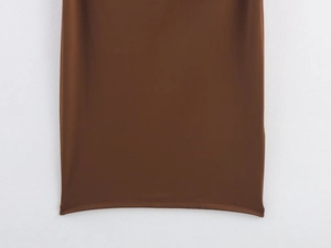 Close-up of the smooth hem stitching on a brown bodycon dress with silky fabric texture