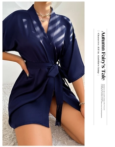 Detail of navy blue satin robe with waist tie, tassel accents and wide kimono sleeves