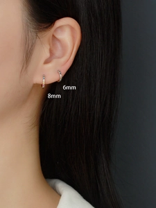 Detail of 6mm and 8mm S925 silver geometric hoop earrings with colorful crystals on model
