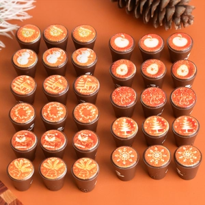 Close-up of assorted Christmas miniature coffee cup charms with snowflake and reindeer patterns