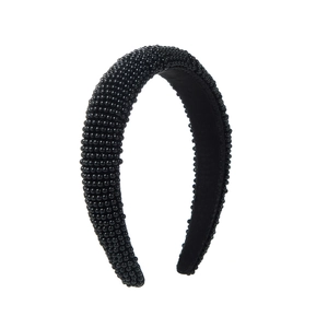 Detail of a padded black headband featuring dense beadwork and non-slip inner velvet lining