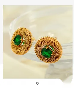 Detail view of vintage woven gold earrings with an oval green gemstone inlay