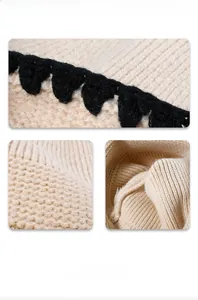 Detail van de dikke beige breistructuur en zwarte gehaakte rand van de wintermuts