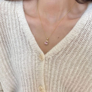 Detailed close-up of a 925 silver gold necklace with pink zircon pendant on a model