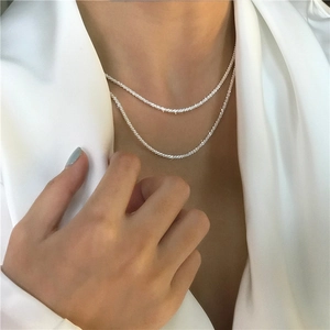 Elegante collana a strati a corda intrecciata argentata indossata da una modella