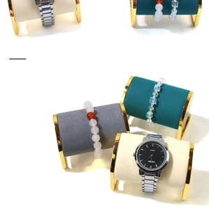 Close-up of velvet jewelry display stands with gold metal frames for watches and bracelets