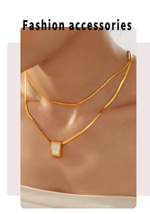 Close-up of a double-layered gold plated necklace with a white square shell pendant