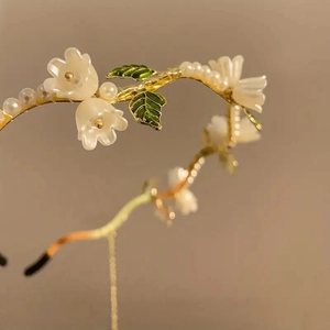 Elegant lily of the valley headband with white flowers, green leaves and pearls