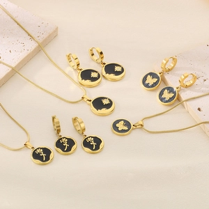 Detail of gold-plated stainless steel jewelry set featuring black butterfly and rose motifs