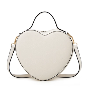 Detailed view of white heart-shaped crossbody bag with refined cross-grain texture