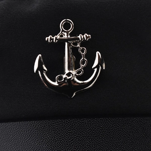 Fashionable anchor badge on black military cap with knit and leather textures
