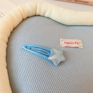 Détail d'une pince à cheveux étoile bleu clair avec texture mate et pailletée