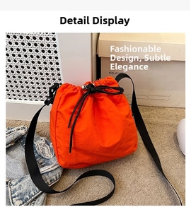 Detail of orange drawstring bucket bag made of lightweight nylon with adjustable strap