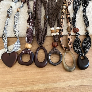Detailed assortment of Bohemian fabric necklaces with wooden and acrylic charms