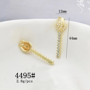 Detailed view of golden flower charms with faux pearls and rhinestones on beige fabric