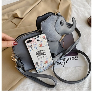 Detail of grey elephant-shaped leather crossbody bag with golden zipper and strap