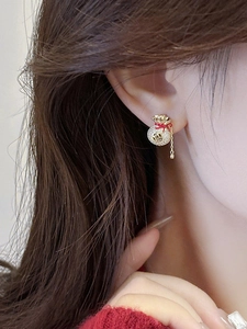 Dettaglio degli orecchini portafortuna in zircone con accenti rossi e lunghe frange