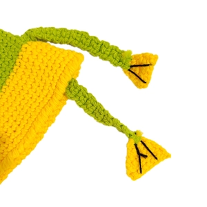Detail of yellow and green hand-knitted frog hat showing wool texture and pom-pom ties