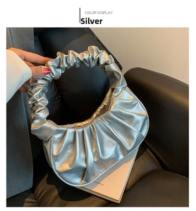 Detail of silver metallic ruched crescent bag showing the iconic pleated handle design