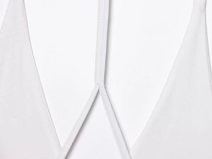 Detail of white halter neck straps and fine stitching on a layered mini dress
