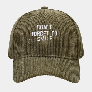 Detailed view of army green corduroy baseball cap with white smile letter embroidery