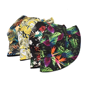 Detailed flat lay of four reversible bucket hats with tropical leaf and pineapple patterns