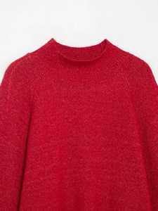 Close-up detail of red mock neck knit sweater with subtle gold glitter thread finish