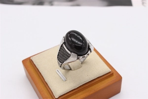 Macro d'une pierre noire ovale sur une bague vintage en acier inoxydable pour homme