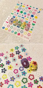Detail of 3D embossed floral and celestial nail art stickers with pearl accents on nails