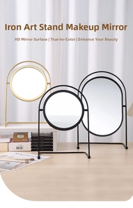 Detailed view of desktop metal vanity mirrors in round and oval shapes on a wooden table