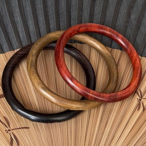 Lot de 3 bracelets joncs en bois naturel d'ébène et séquoia sur fond d'éventail en bambou
