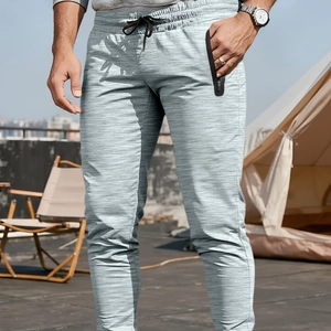 Pantaloni jogger fitness da uomo grigio chiaro con polsini aderenti in scena outdoor
