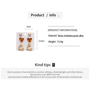 Detail view of heart and square stud earrings with resin and imitation pearl materials