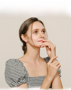 Close-up of elegant square opal stud earrings worn by a model in a minimal lifestyle setting