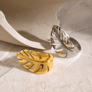 Polished 18k gold and silver stainless steel monstera leaf open rings on stone base