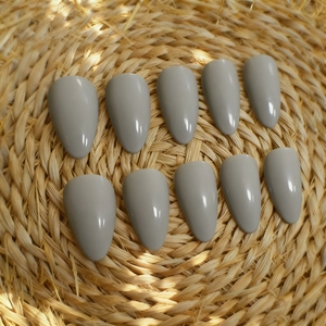 24pcs glossy grey almond press-on nails set displayed on a natural woven textured background