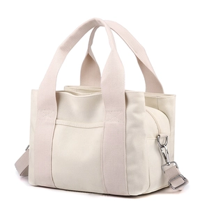 Minimalist off-white canvas tote bag with adjustable shoulder strap and top handles