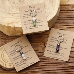 Detail of handmade stone beaded keychains with healing crystal description cards