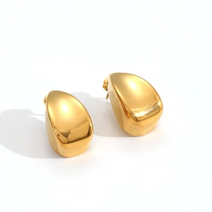 Macro shot of polished gold water drop earrings showing shiny metallic surface