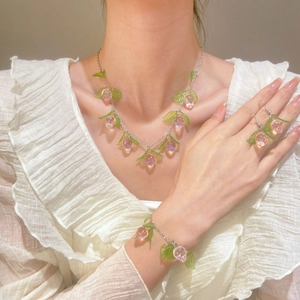 Sweet pink peach jewelry set including necklace, bracelet and earrings on female model