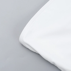 Close-up of white dress fabric showing high-quality stitching and fine mesh texture