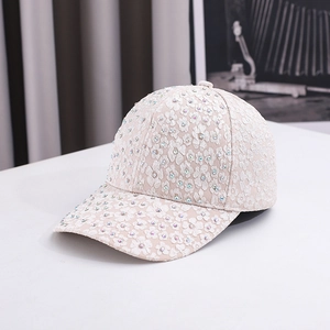 Close-up of the elegant white lace fabric and sparkling colorful rhinestones on the baseball cap